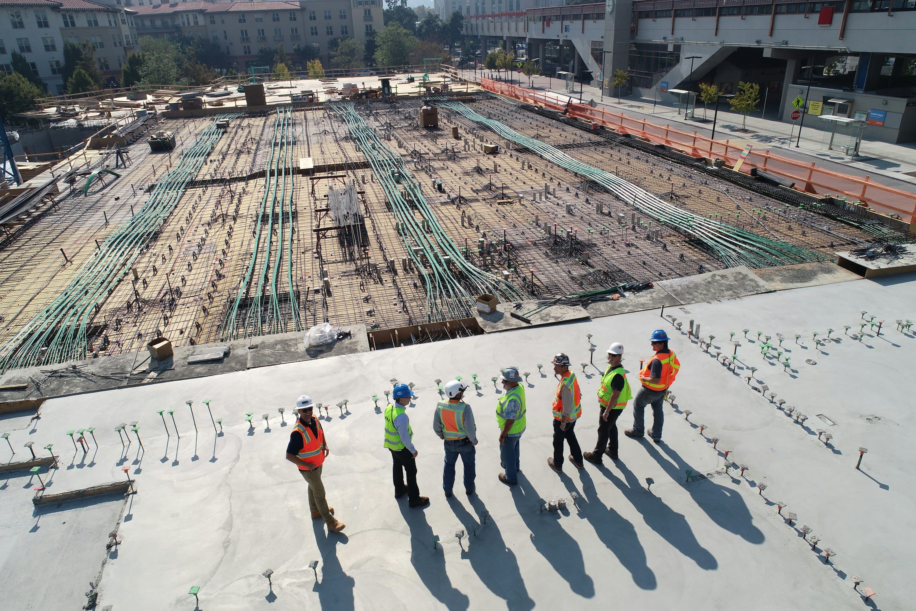 Construction workers coordinating beside a reinforced concrete worksite